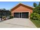 Exterior view of the detached garage, complete with black-screened doors and a concrete driveway at 2513 Martucci Rd, Seffner, FL 33584