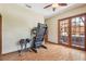 Room with wood-look floor has exercise equipment and view to hot tub and outdoor space via French doors at 2513 Martucci Rd, Seffner, FL 33584