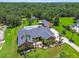 Aerial view of property showcasing the manicured lawn, mature landscaping, a detached garage, and caged pool at 2513 Martucci Rd, Seffner, FL 33584