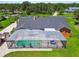 Rear aerial view of the home featuring a screened pool enclosure, blue lounge chairs, and well-kept landscaping at 2513 Martucci Rd, Seffner, FL 33584
