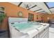 Hot tub with water feature, ceiling fan, and seating area on the lanai at 2513 Martucci Rd, Seffner, FL 33584