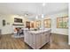 Open-concept kitchen with granite island, stainless appliances, and wood flooring with a fireplace in the background at 2513 Martucci Rd, Seffner, FL 33584