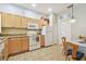 This kitchen has wood cabinets, tile flooring, white appliances, and a dining area, creating a cozy and functional space at 2513 Martucci Rd, Seffner, FL 33584