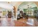Open-concept living room with hardwood and tile flooring, ceiling fans, and multiple arched windows at 2513 Martucci Rd, Seffner, FL 33584