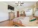 Main bedroom with wood furniture, colorful bedspread, wood floors, and ceiling fan, with lots of light at 2513 Martucci Rd, Seffner, FL 33584