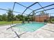 Enclosed swimming pool with waterfall feature, paved surround, and lush green yard at 2513 Martucci Rd, Seffner, FL 33584