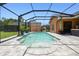 Enclosed swimming pool with waterfall feature and paved surround near an orange house at 2513 Martucci Rd, Seffner, FL 33584
