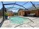Enclosed swimming pool with waterfall feature near a hot tub on a paved surround at 2513 Martucci Rd, Seffner, FL 33584