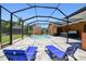 Enclosed pool with lounge chairs, hot tub, and outdoor kitchen in a paved lanai at 2513 Martucci Rd, Seffner, FL 33584