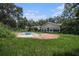 Spacious backyard with a pool, patio, overgrown grass, and a house at 36251 Horseshoe Dr, Zephyrhills, FL 33541