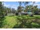 Backyard with a two-car garage, overgrown grass, and a pool at 36251 Horseshoe Dr, Zephyrhills, FL 33541