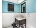 Bathroom showcasing blue walls, a framed mirror, and a black vanity at 36251 Horseshoe Dr, Zephyrhills, FL 33541
