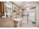 Bathroom featuring a clear-door shower, sink, and open window at 36251 Horseshoe Dr, Zephyrhills, FL 33541