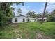 Inviting home exterior with lush greenery, a detached garage, and ample space for outdoor activities at 36251 Horseshoe Dr, Zephyrhills, FL 33541