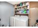 Functional laundry room with side by side washer and dryer, and storage shelving for convenience at 36251 Horseshoe Dr, Zephyrhills, FL 33541