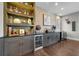 Elegant bar area with custom shelving, stone accent wall, wine refrigerator, and granite countertops at 4525 W Swann Ave, Tampa, FL 33609