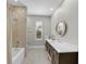 Bathroom with a tub and shower, large vanity and mirror, and natural light at 4525 W Swann Ave, Tampa, FL 33609