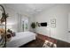 Bright bedroom with hardwood floors, neutral walls, ceiling fan, and double doors to a small private balcony at 4525 W Swann Ave, Tampa, FL 33609