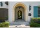 Arched entrance featuring stone details, custom lighting, and well-maintained landscaping at 4525 W Swann Ave, Tampa, FL 33609