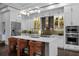 Modern kitchen featuring white cabinets, stainless steel appliances, and an island with seating at 4525 W Swann Ave, Tampa, FL 33609