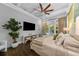 Bright main bedroom with a ceiling fan, wood floors, television and access to the backyard pool area at 4525 W Swann Ave, Tampa, FL 33609
