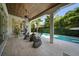 This covered patio offers seamless indoor/outdoor living with oversized chairs and views of the pool at 4525 W Swann Ave, Tampa, FL 33609