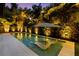 A serene pool featuring built-in lounge chairs and a tranquil ambiance with lush landscaping and gentle lighting at 4525 W Swann Ave, Tampa, FL 33609