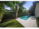 The in-ground pool with integrated chaise lounges is surrounded by lush landscaping in this backyard oasis at 4525 W Swann Ave, Tampa, FL 33609