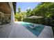 An in-ground pool with integrated chaise lounges sits among lush landscaping in this backyard oasis at 4525 W Swann Ave, Tampa, FL 33609