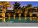 A beautifully lit pool with lounge chairs, set against a backdrop of lush tropical landscaping and a picturesque sky at 4525 W Swann Ave, Tampa, FL 33609
