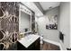 Stylish powder room boasts unique wallpaper, an artistic mirror, and contemporary vanity at 4525 W Swann Ave, Tampa, FL 33609