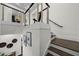 Modern staircase featuring hardwood steps, white risers, and stainless steel cable railings at 4525 W Swann Ave, Tampa, FL 33609