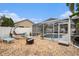 Backyard featuring gravel, lounge chairs, and a screened-in pool at 4738 Bloom Dr, Plant City, FL 33566