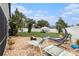 Backyard featuring gravel, lounge chairs, and a greenhouse behind a white fence at 4738 Bloom Dr, Plant City, FL 33566