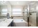 Bathroom features a garden tub, glass shower with beige tiling and decorative accent tiles, and ample vanity space at 4738 Bloom Dr, Plant City, FL 33566