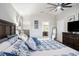 Large bedroom with king bed featuring a ceiling fan, vaulted ceilings, blue accents and an en-suite bathroom at 4738 Bloom Dr, Plant City, FL 33566