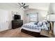 Spacious bedroom features a ceiling fan, a king bed with blue patterned bedding, and a dark wood dresser with TV at 4738 Bloom Dr, Plant City, FL 33566