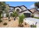 Home exterior with stone landscaping, mature trees and plants, and a two-car garage at 4738 Bloom Dr, Plant City, FL 33566
