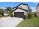 Exterior view of two-story home highlighting the garage and partial landscaped yard at 4738 Bloom Dr, Plant City, FL 33566