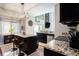 Bright kitchen with dark cabinetry, granite counters, stainless appliances, an island with breakfast bar, and elegant chandelier at 4738 Bloom Dr, Plant City, FL 33566