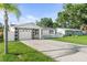 Charming single-story home featuring a manicured lawn, long driveway, and a black and white color scheme at 4741 76Th N Ave, Pinellas Park, FL 33781
