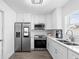 Bright kitchen features stainless steel appliances, white cabinets, and wood-look flooring at 4741 76Th N Ave, Pinellas Park, FL 33781