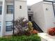 Exterior view of a two-story condo building with black stairs and colorful landscaping at 4811 Puritan Cir # 4811, Tampa, FL 33617