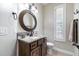 Stylish bathroom featuring granite countertop, a decorative round mirror, and white toilet at 539 Treviso Dr, Apollo Beach, FL 33572