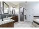 Bathroom featuring granite counters, updated cabinetry, walk-in shower, and soaking tub at 539 Treviso Dr, Apollo Beach, FL 33572