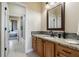 Bathroom vanity featuring granite countertop, framed mirror, and wood cabinetry, offering style and functionality at 539 Treviso Dr, Apollo Beach, FL 33572