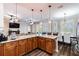 Stylish open kitchen with granite countertops, pendant lighting, wooden cabinetry and seating overlooking the fireplace in the living room at 539 Treviso Dr, Apollo Beach, FL 33572