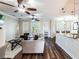 Bright and airy living room with wood floors, modern furnishings, ceiling fans, and natural light from shuttered french doors at 539 Treviso Dr, Apollo Beach, FL 33572