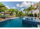 Backyard pool featuring a tanning ledge and lush tropical landscaping, perfect for relaxing and entertaining at 539 Treviso Dr, Apollo Beach, FL 33572