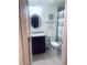 Bathroom with a granite vanity, framed oval mirror, toilet, and shower with striped curtain at 5720 Palmer Cir # 102, Bradenton, FL 34211